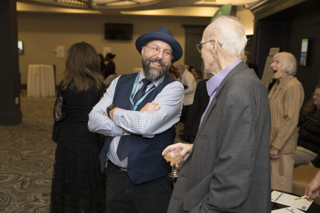 Counsellor Fabio speaking to a guest at the banquet